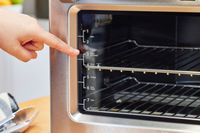 A hand pointing to the Breville the Smart Oven Air Fryer