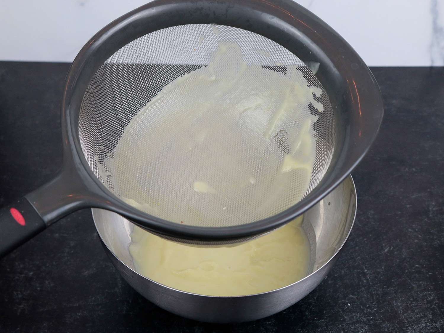 pureed soup in a strainer, showing very little material left behind after blending