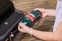 A person attaches a propane tank to the Weber Slate 22 inch Rust-Resistant Tabletop Griddle
