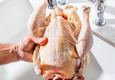 Overhead view of washing a chicken in the sink 