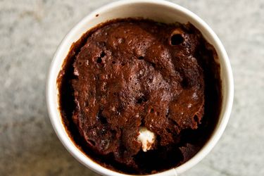 Overhead closeup of a microwave rocky road sponge cake, served in a ramekin.