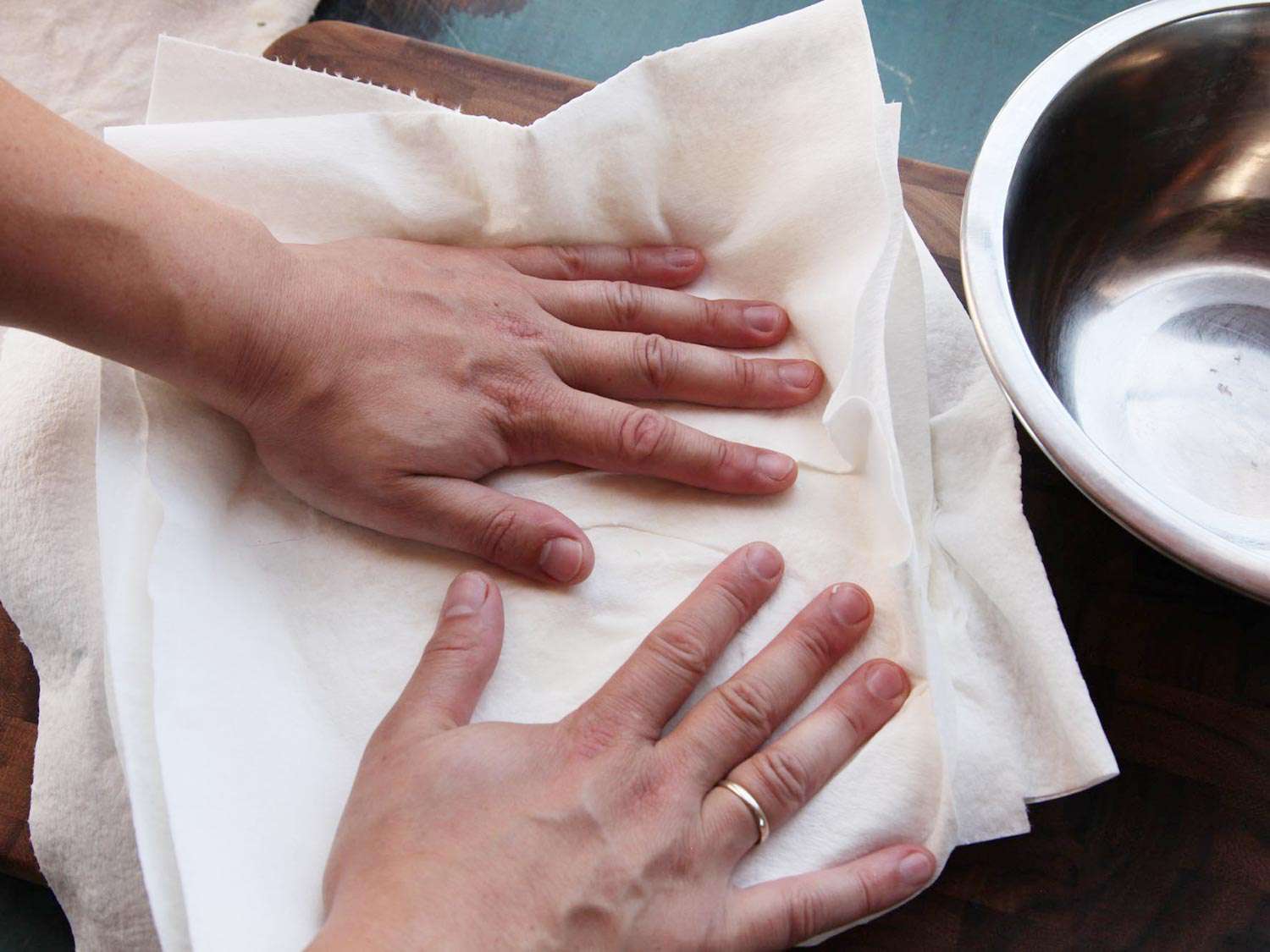 Pressing paper towel on ricotta to drain it. 