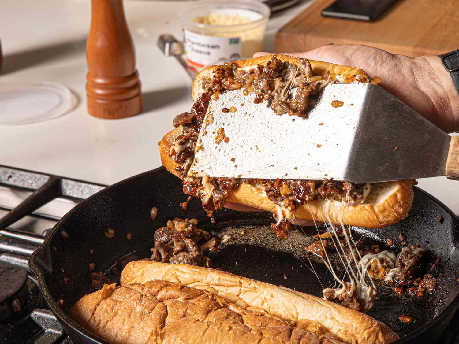 Step 5. cheesesteaks being assembled with spatula