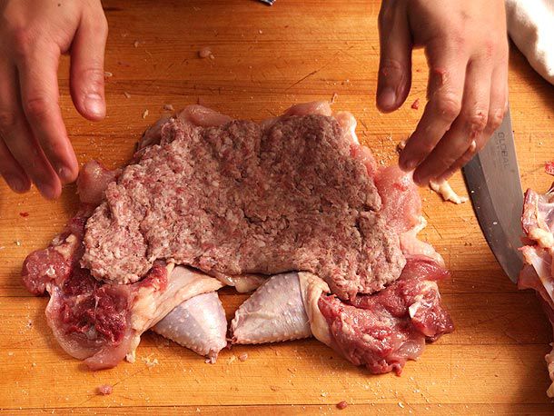 Layer of sage sausage pressed on top of whole deboned, butterflied chicken 