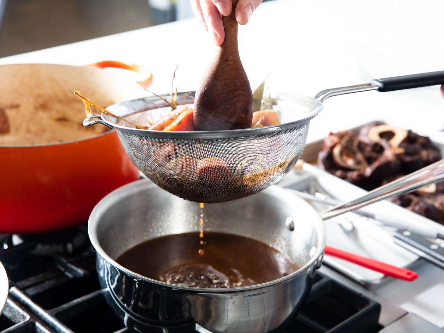 The reduced mixture is strained into a saucier.