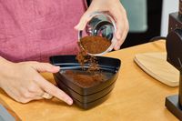 A person pours coffee grounds from the Fellow Ode Gen 2 Coffee Grinder onto a plate