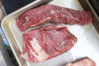 Raw Good Chop steaks seasoned and arranged on a metal baking tray