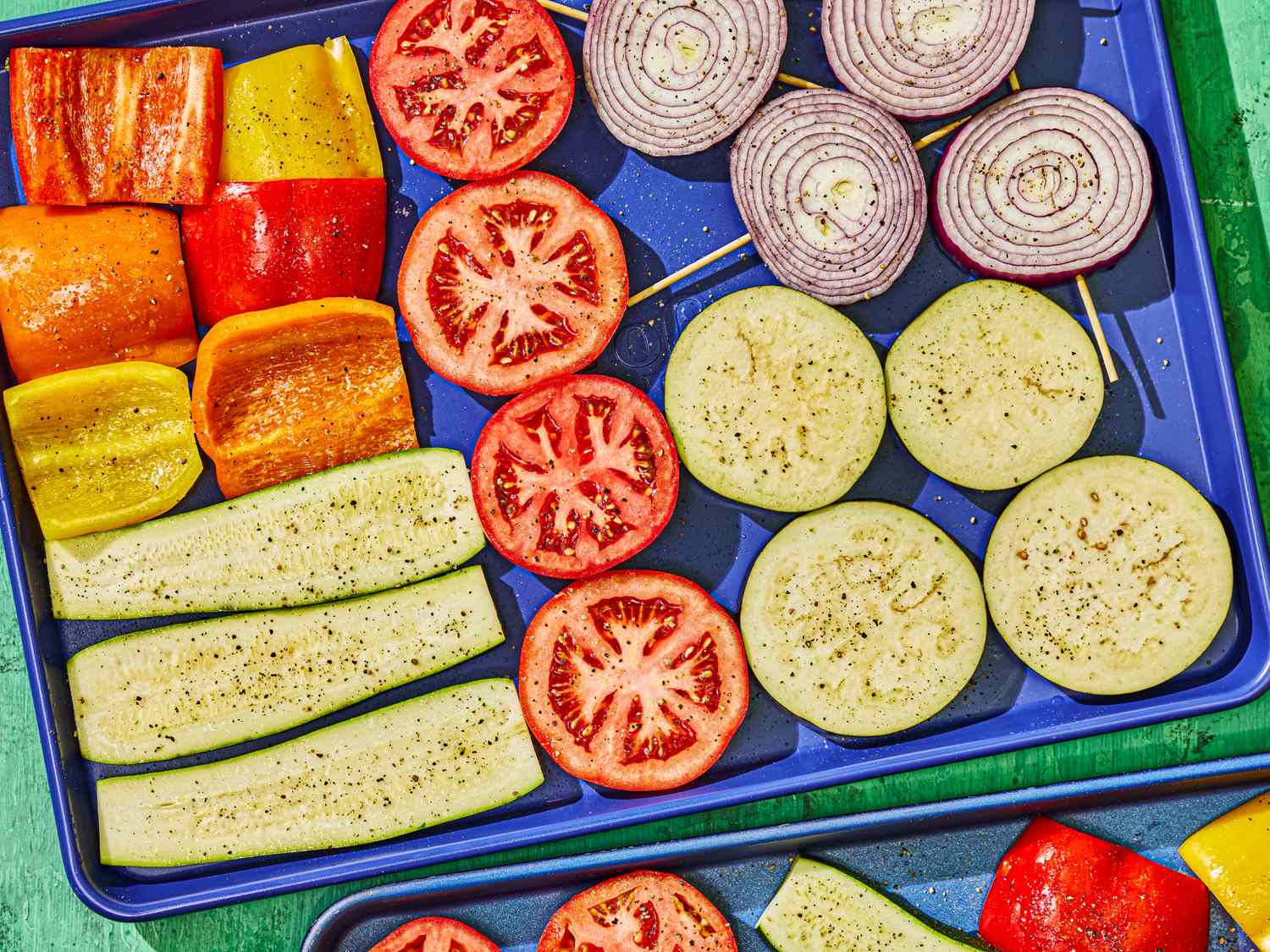 Assorted vegetables sliced and seasoned, arranged on a tray for cooking