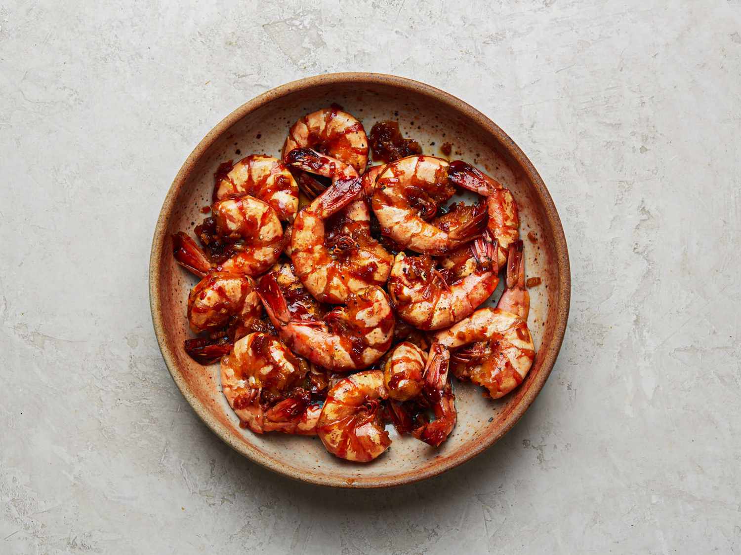 Overhead view of braised shrimp on a plate