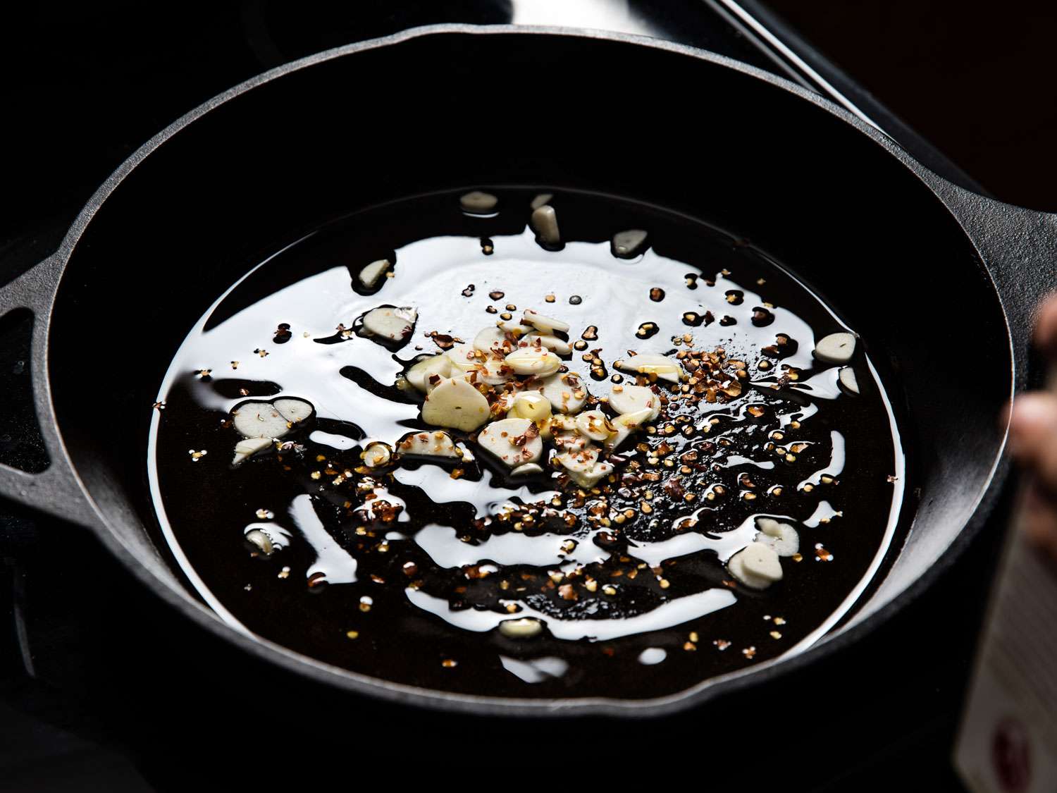 Sautéing garlic and red pepper flakes in olive oil.
