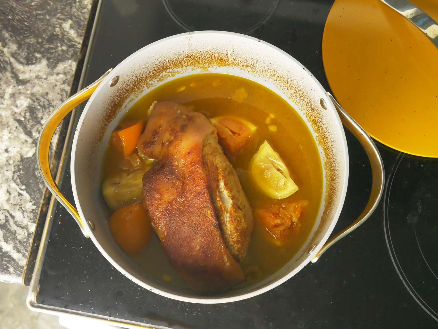 overhead shot of braised pork in yellow dutch oven