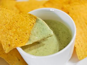 Tortilla chip dipped in salsa verde