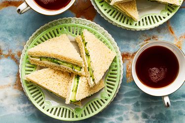 Overhead view of cucumber sandwiches on a green plate