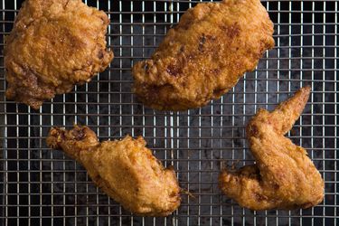 Fried chicken on a wire rack set inside a baking sheet