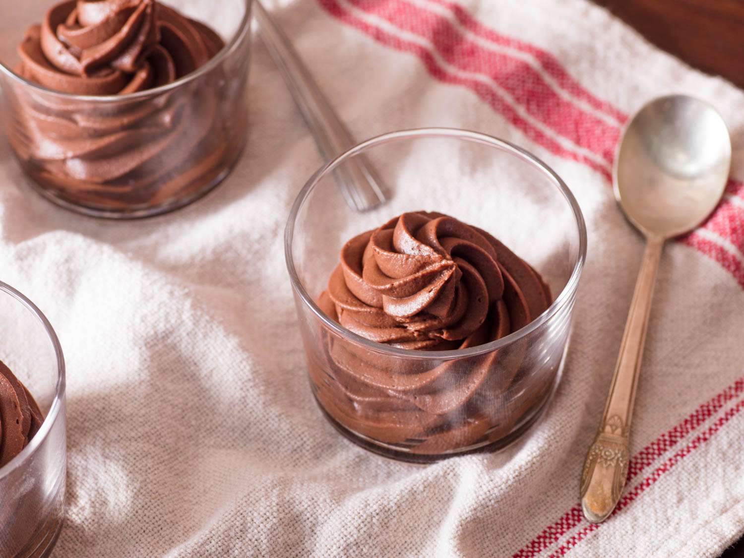 Glass cups filled with piped egg-free chocolate mousse.