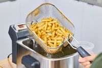 French fries are removed from the Breville BDF500XL Smart Fryer