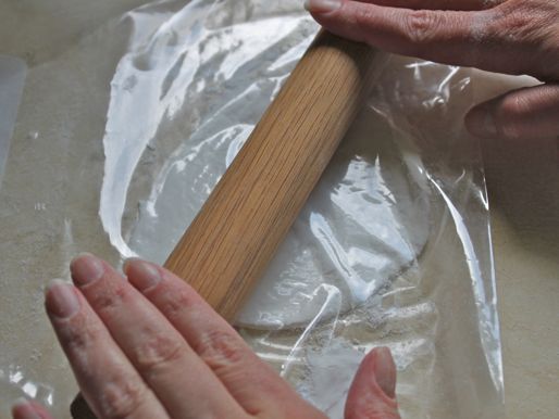 Author rolls out a thick tortilla with a rolling pin.