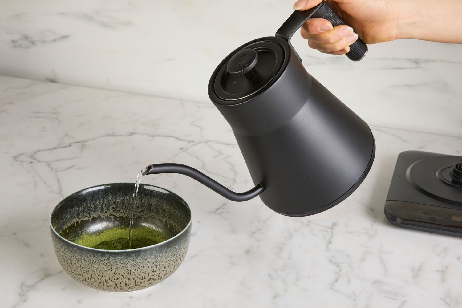 Person pouring water from Saki Baristan Electric Gooseneck Kettle