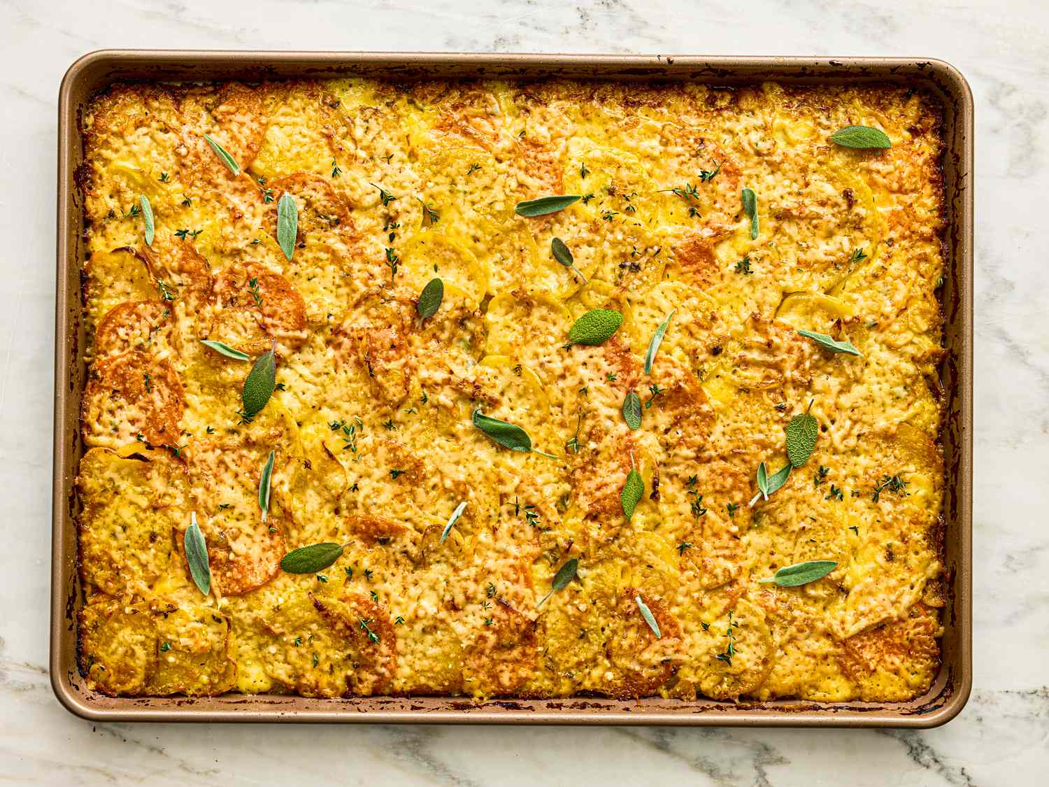 Baked dish of root vegetable gratin garnished with herbs in a sheet pan