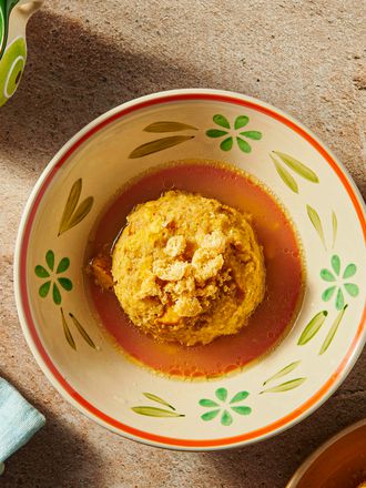 Bowl of Mofongo from above in a bone colored dish with flowers on it, and edges of other bowls of mofongo on the bottom rightside. 