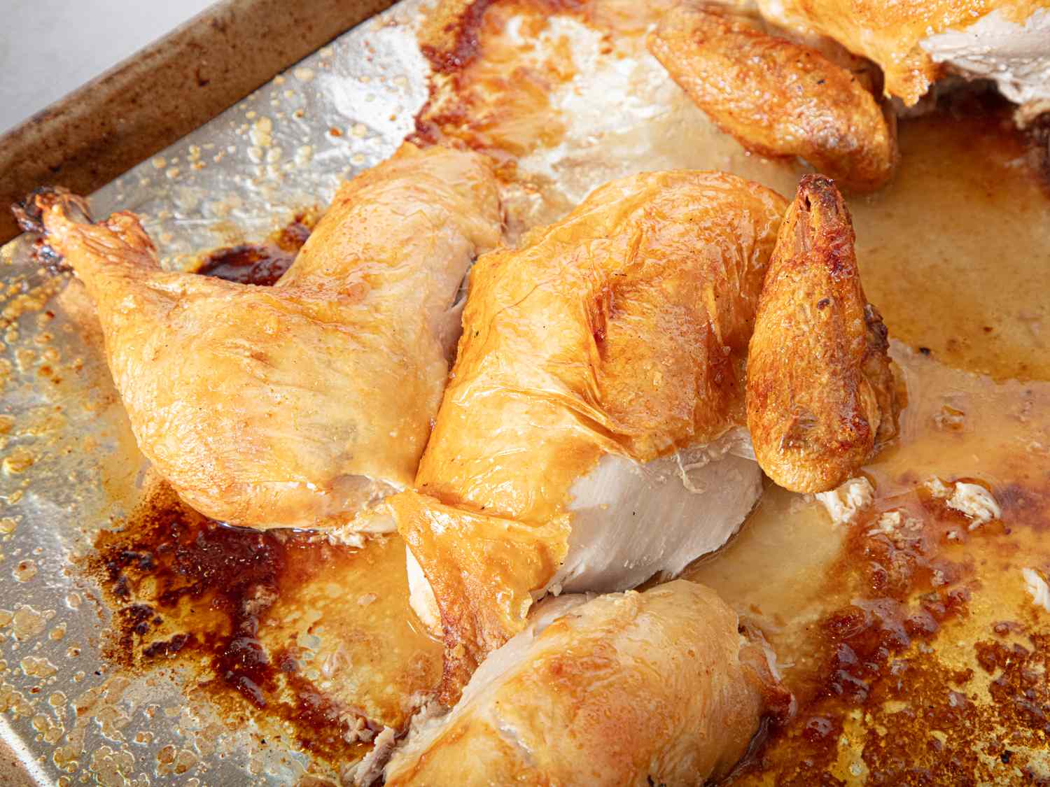 Roasted chicken on a baking tray cut into servings