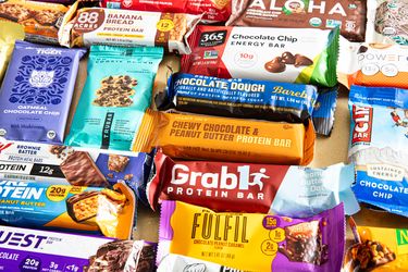 A variety of protein bars placed together displaying different brands and flavors