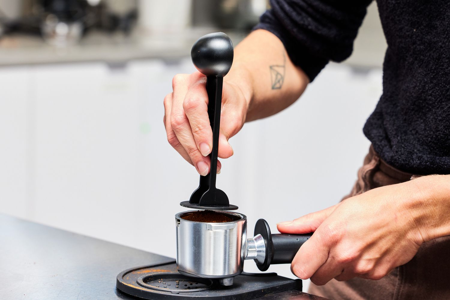 Hands adjusting the portafilter that will go into the De'Longhi Stilosa Espresso Machine