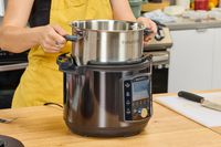 A person removes the inner pot on the Instant Pot Pro 10-in-1 6-Quart Pressure Cooker