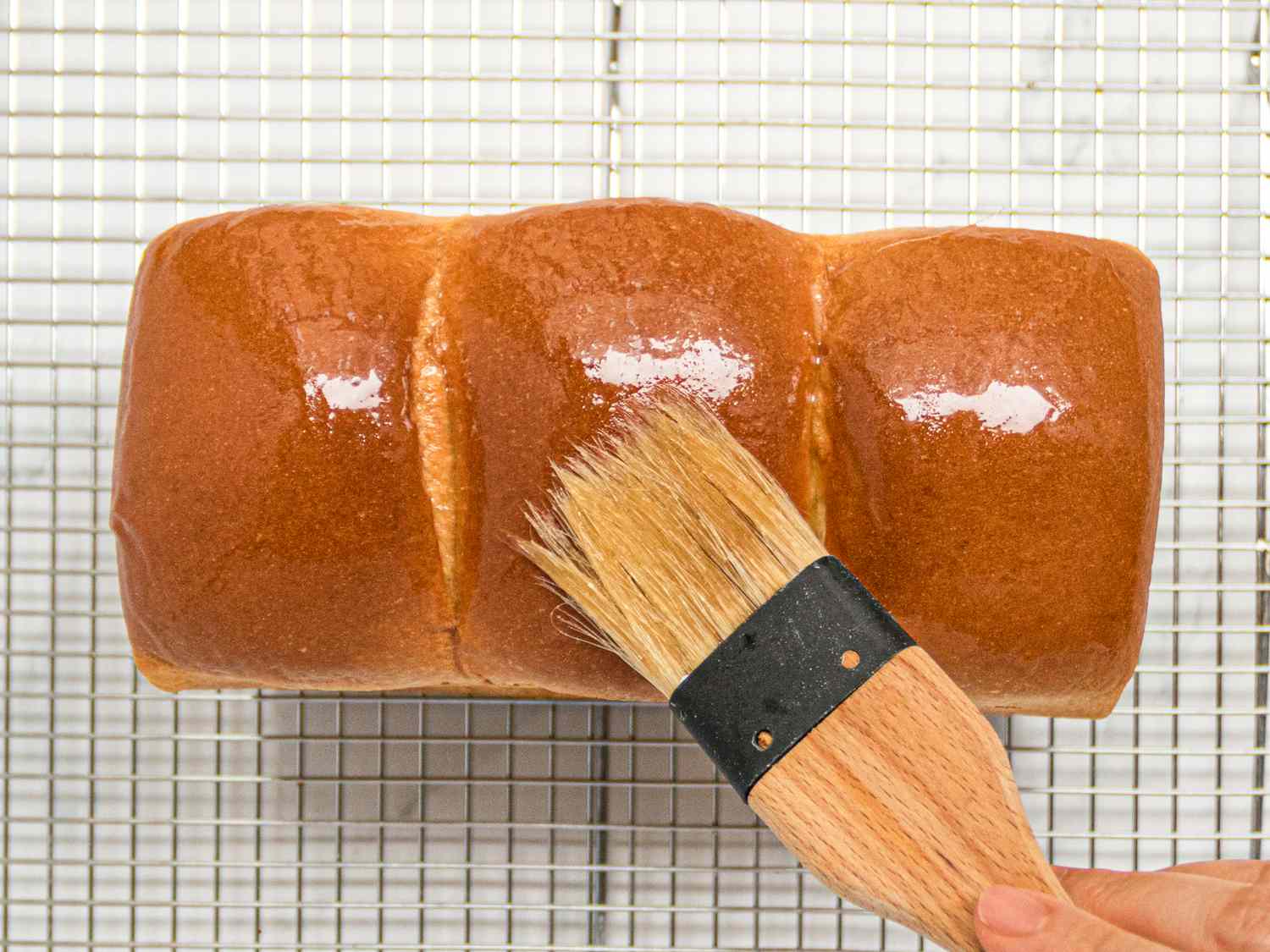 Overhead view of adding butter to milk bread