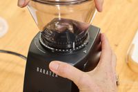 A person turns a dial on the Baratza ZCG495 Encore ESP Coffee Grinder