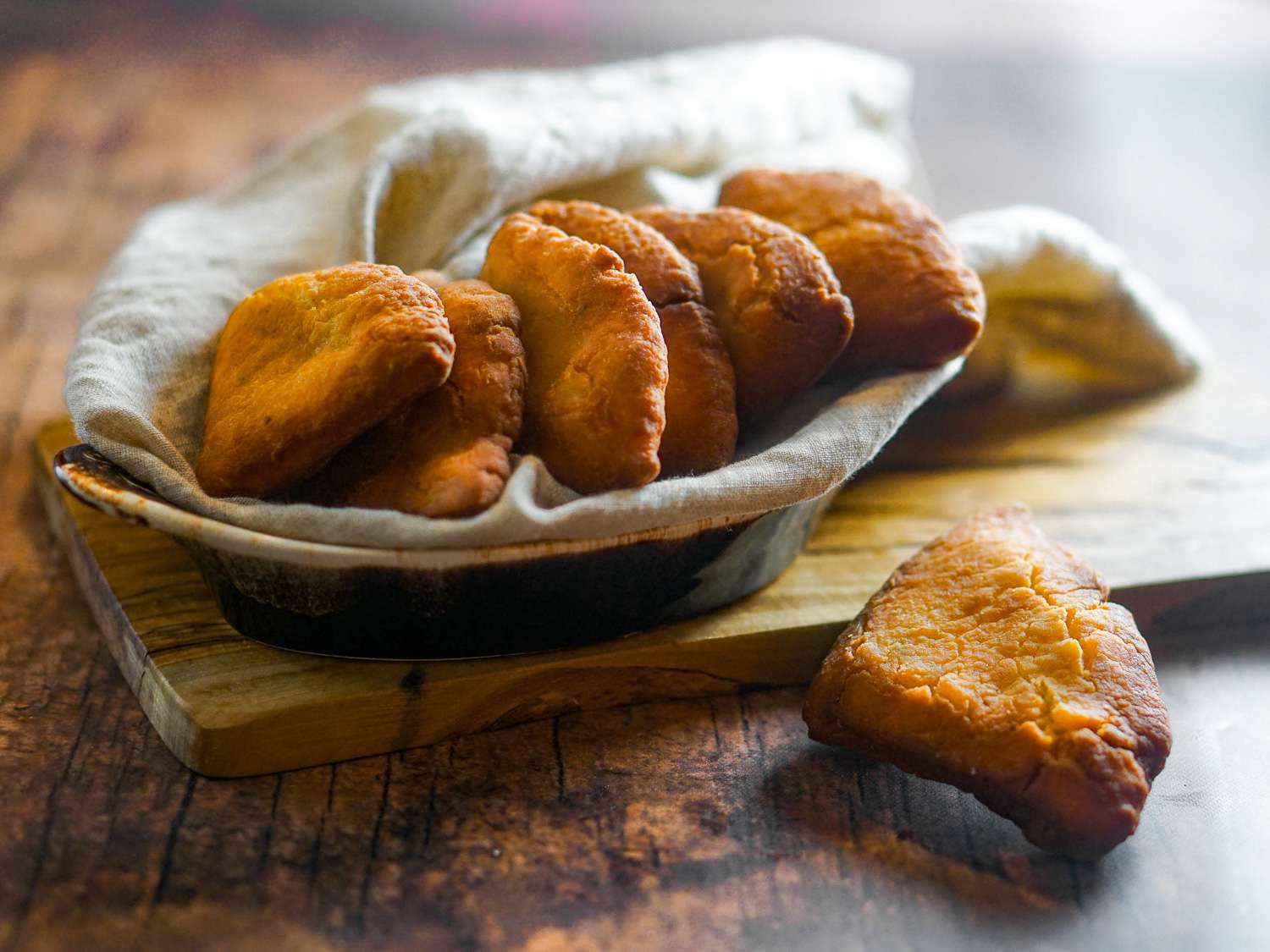 A basket of mandazi on a wooden background