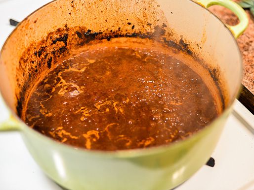 The braising liquid is simmered and reduced.