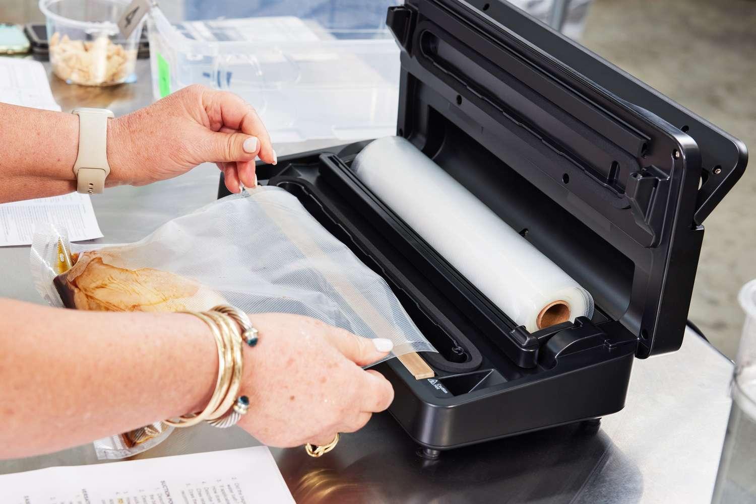 A person using Anova Precision Vacuum Sealer Pro to seal a food bag