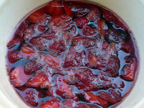 Closeup of macerated strawberries, submerged in their own osmosed juices.