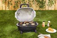 The PK grills portable charcoal grill cooking sausages.