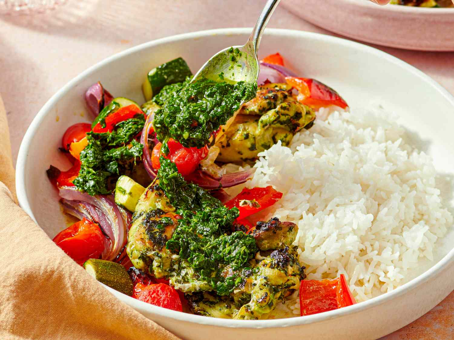 Served dish of chimichurri chicken thighs with rice and vegetables on a plate