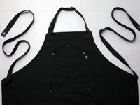 Hexclad apron on a white tile surface
