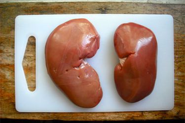 Overhead view of two kidneys on a cutting board.