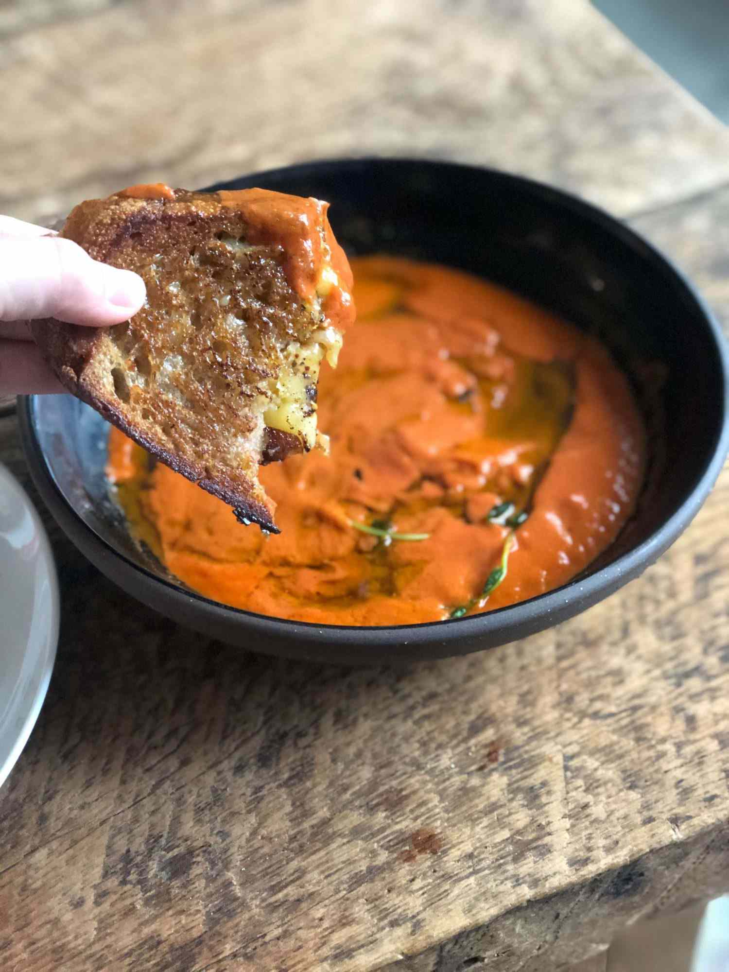 Chili crisp cream cheese with a bowl of tomato soup for dipping