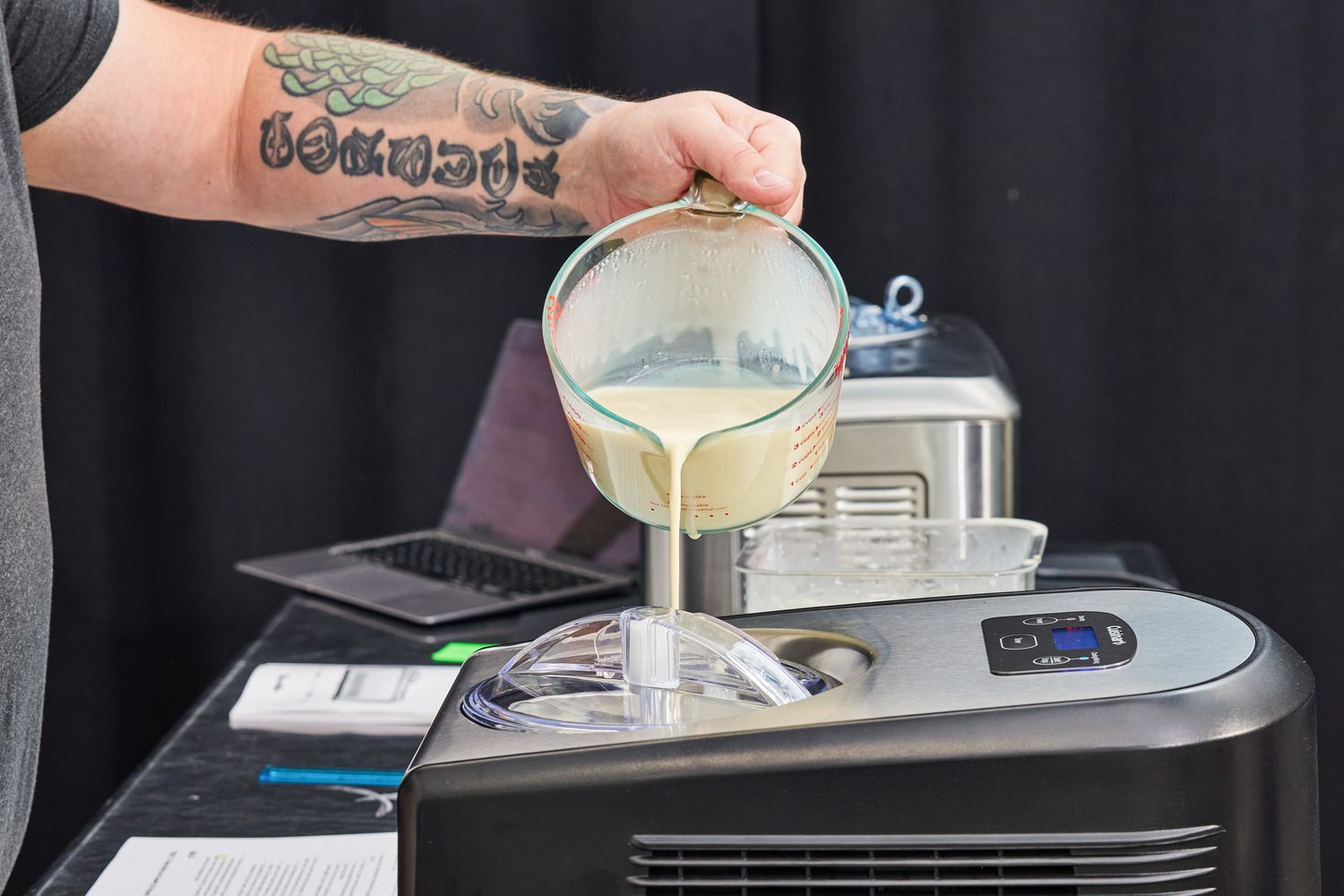 Hand pouring liquid ice cream base into Cuisinart ICE-100 Compressor Ice Cream and Gelato Maker