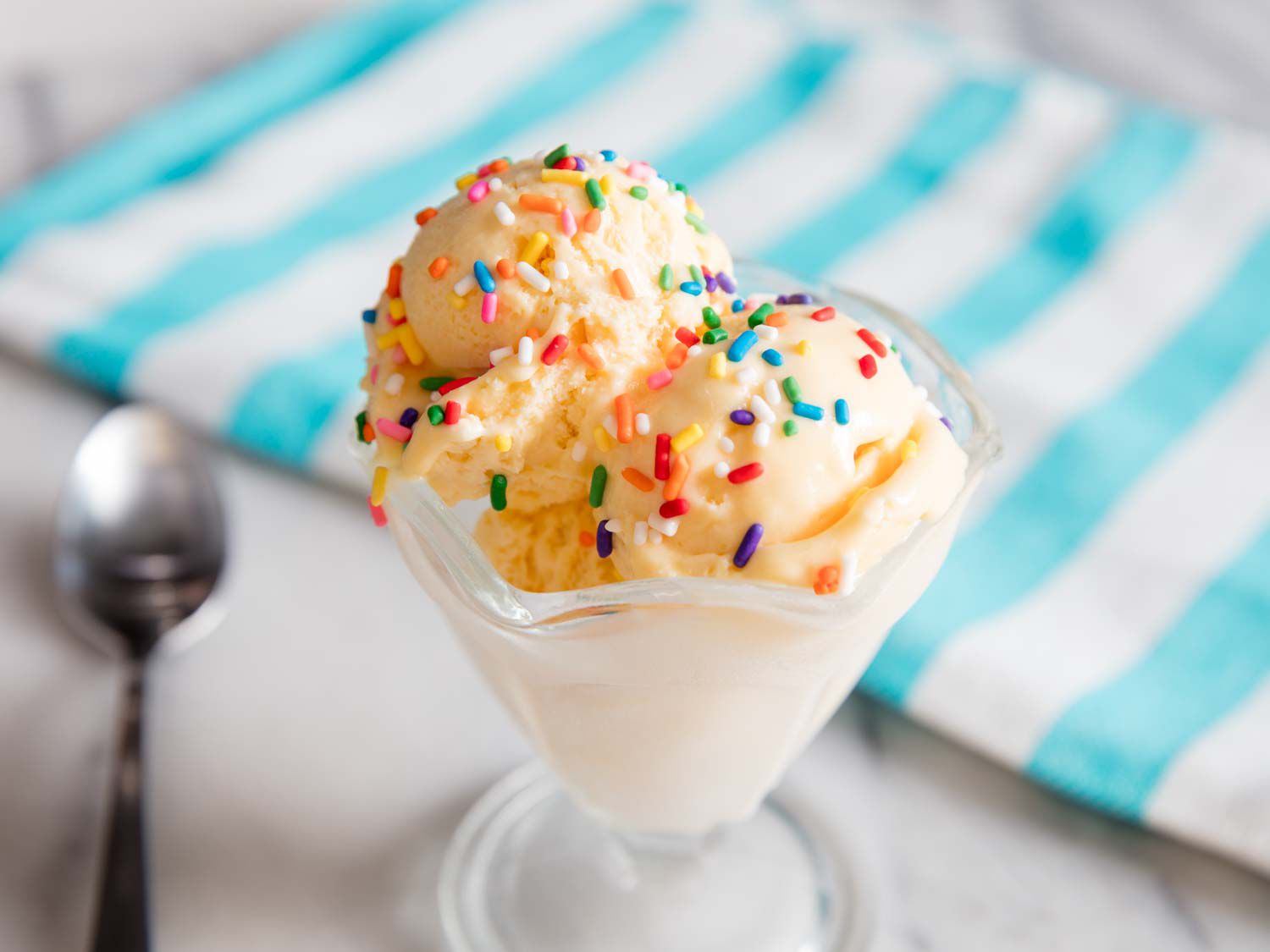 No churn vanilla ice cream in a sundae cup with rainbow sprinkles