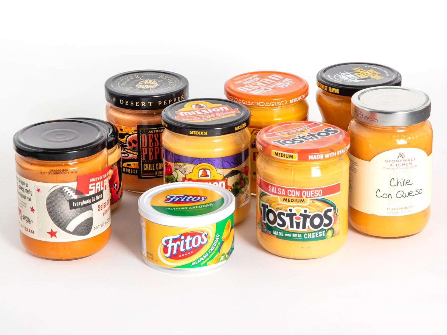 A group of nine queso dips in jars against a white background.