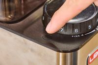 A person adjusts the grind setting on the Lelit William Espresso Grinder
