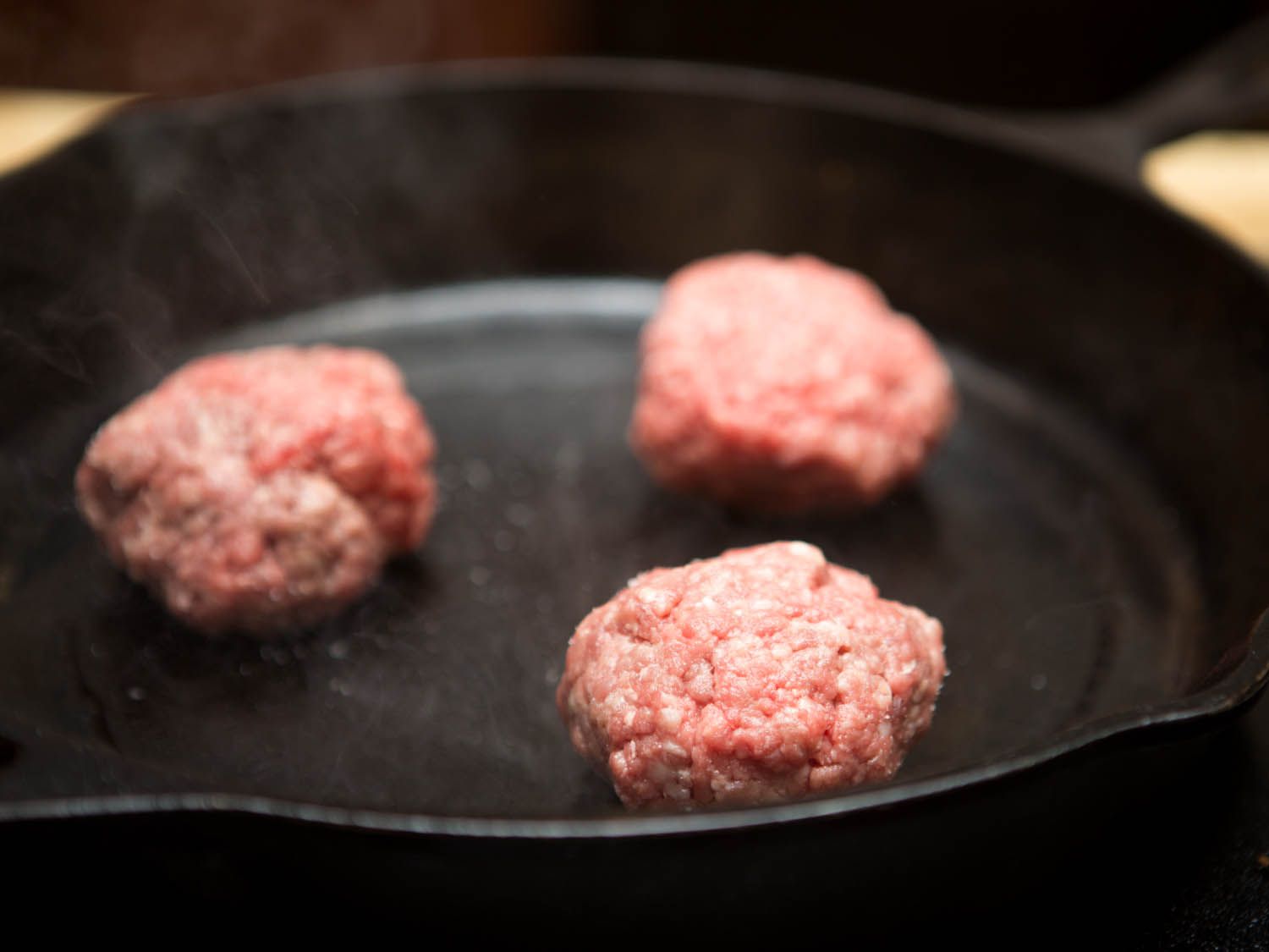 burger patties in cast iron skillet