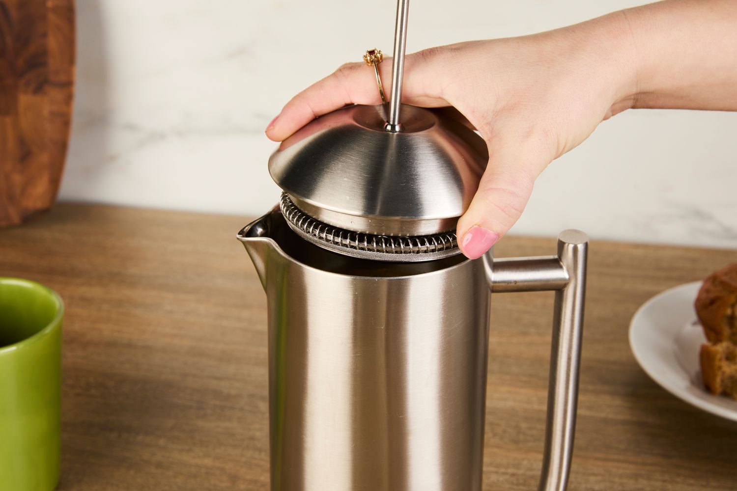 The top being added to a stainless steel French press.