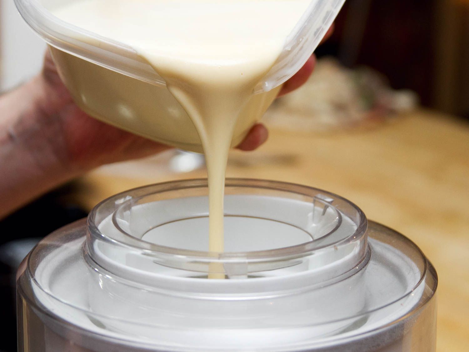 Pouring custard for ice cream into a tabletop ice cream maker. 