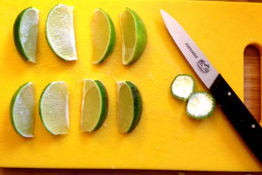 Lime wedges resting on a cutting board