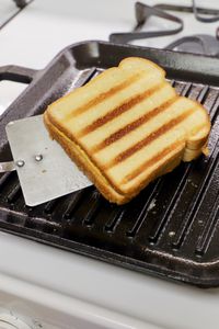 Spatula flipping grilled cheese on Lodge Chef Collection 11-Inch Cast Iron Square Grill Pan