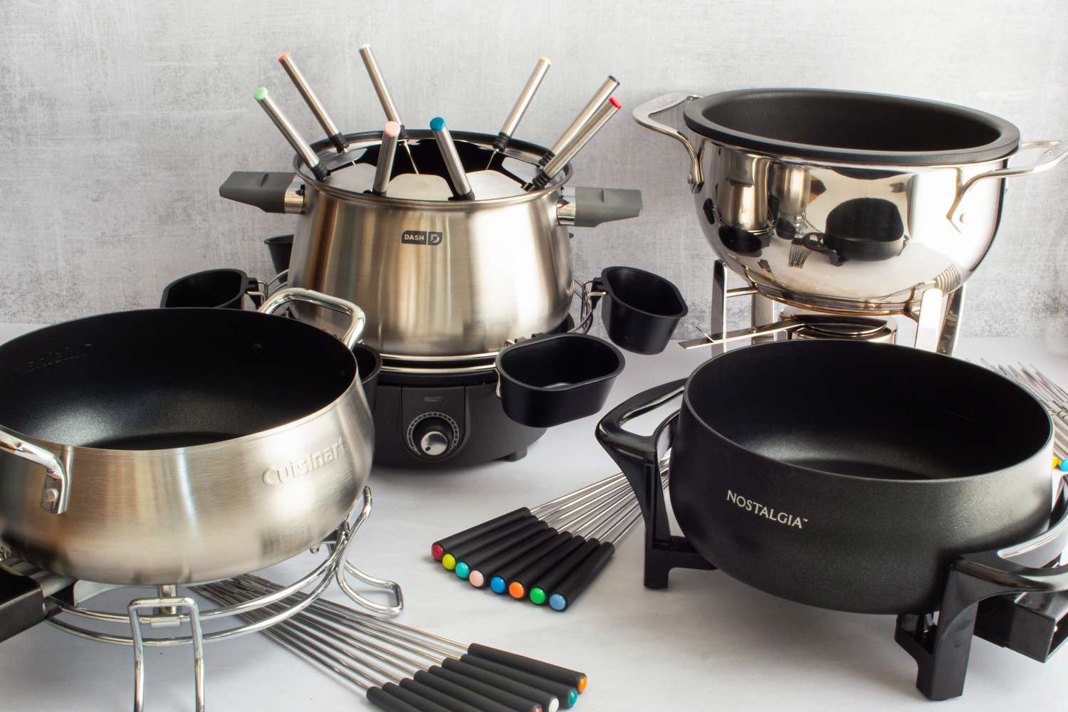 Four fondue posts on a light grey countertop.