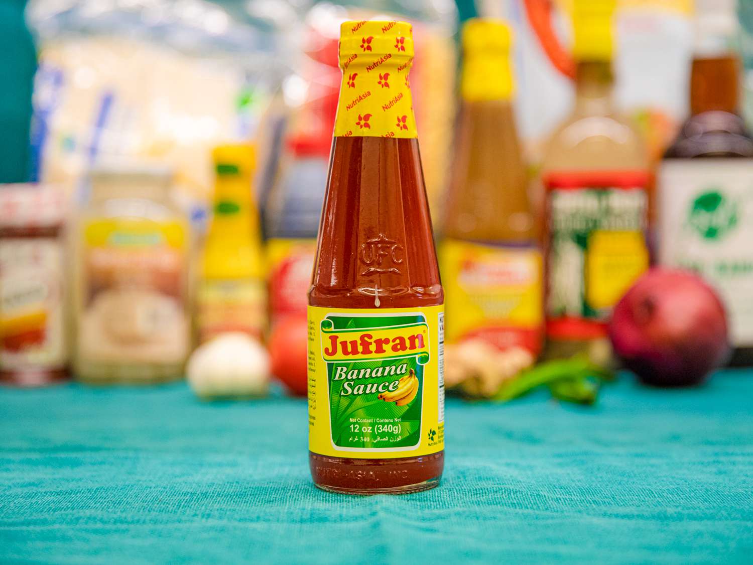 A bottle of Jufran Banana Sauce on a blue backdrop